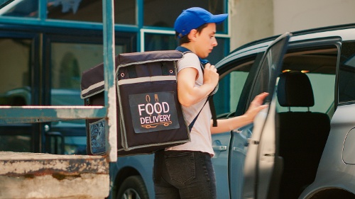 delivery-employee-leaving-vehicle-to-deliver-food-2022-12-22-13-49-35-utc-1